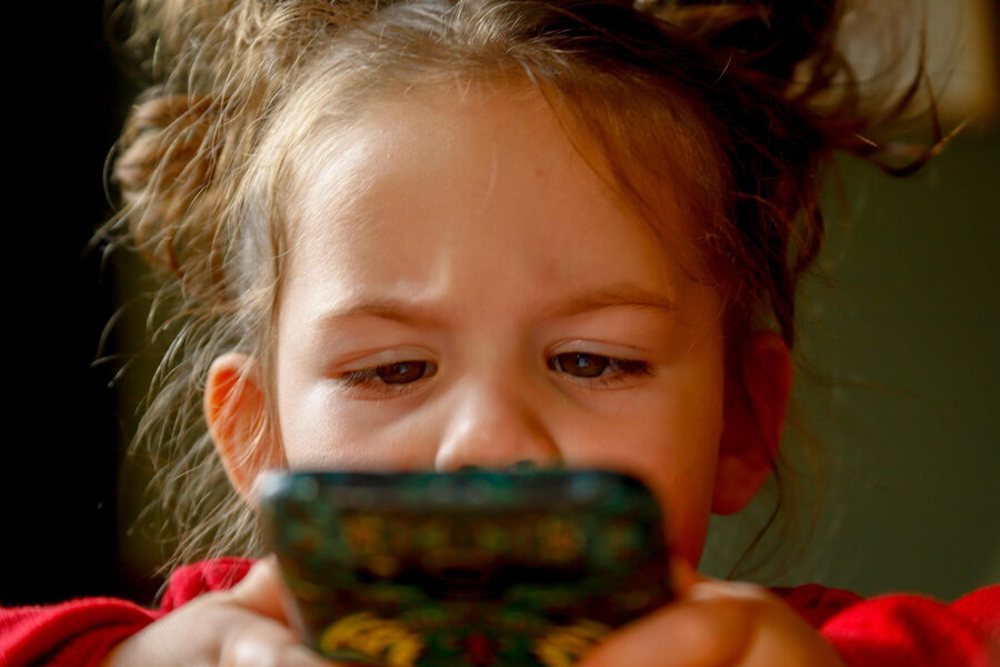 Niña mirando la pantalla de un móvil de cerca